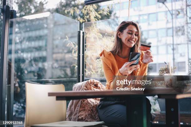 la joven está comprando en línea, usando su teléfono móvil. concepto covid-19. - compra por tarjeta de crédito fotografías e imágenes de stock