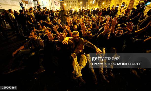 Demonstrators sit on the street as they take part in a protest against the Bank of Italy in the centre of Rome on October 13, 2011 after President of...