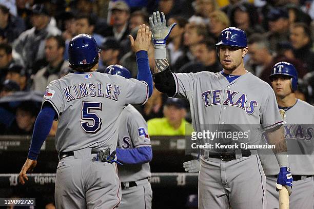 Ian Kinsler of the Texas Rangers celebrates after scoring on a single by Elvis Andrus with Josh Hamilton in the sixth inning of Game Four of the...