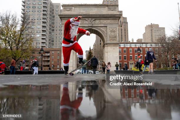 Alex Lopez dressed in a Santa Claus costume performs a skateboard trick during the Sleigh Sessions 2020 ride beginning in Washington Square Park on...