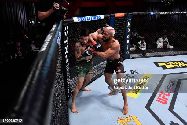 Deiveson Figueiredo of Brazil punches Brandon Moreno of Mexico in their flyweight championship bout during the UFC 256 event at UFC APEX on December...