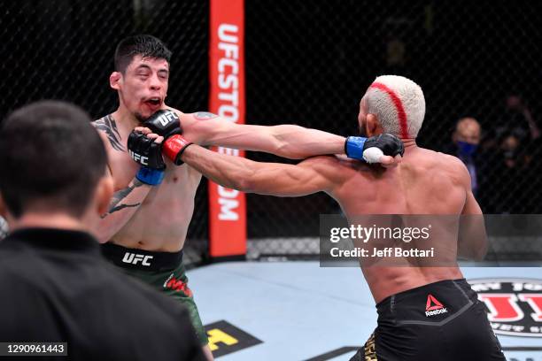 Deiveson Figueiredo of Brazil and Brandon Moreno of Mexico exchange punches in their flyweight championship bout during the UFC 256 event at UFC APEX...