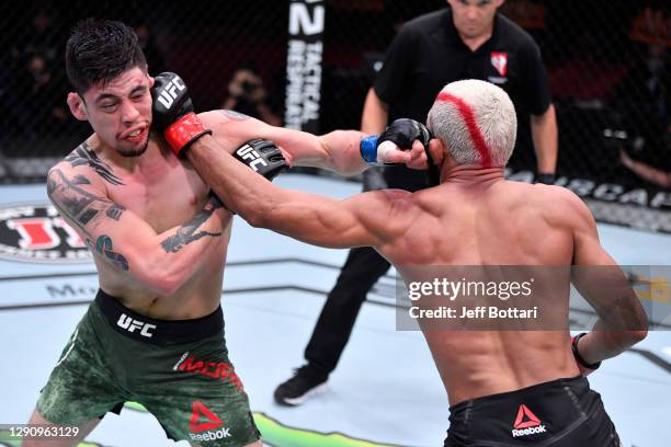 Brandon Moreno of Mexico and Deiveson Figueiredo of Brazil exchange punches in their flyweight championship bout during the UFC 256 event at UFC APEX...