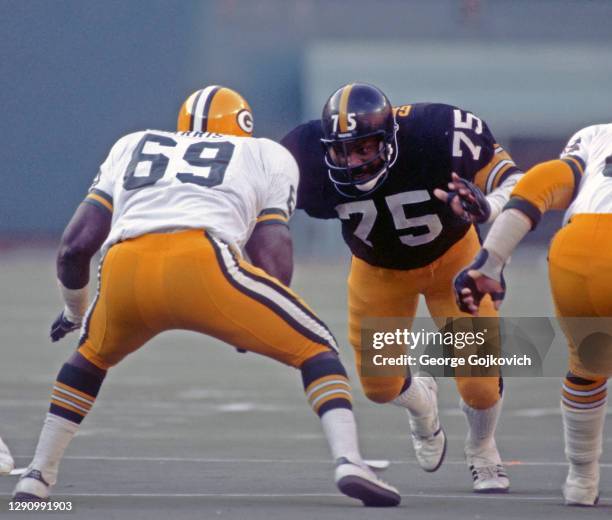 Defensive lineman Joe Greene of the Pittsburgh Steelers pursues the play against offensive lineman Leotis Harris of the Green Bay Packers during a...