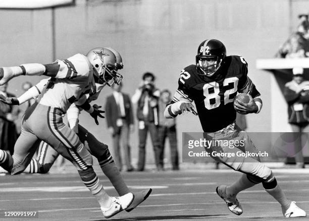 Wide receiver John Stallworth of the Pittsburgh Steelers runs with the football after catching a pass as he is pursued by defensive backs Dennis...