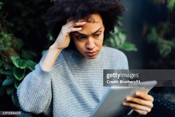 young african american woman reading bad news on her mobile device - surprised woman looking at tablet stock pictures, royalty-free photos & images