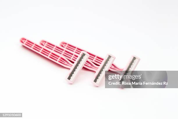 three new disposable razors in white background. selective focus and copy space. - razor blade stock pictures, royalty-free photos & images