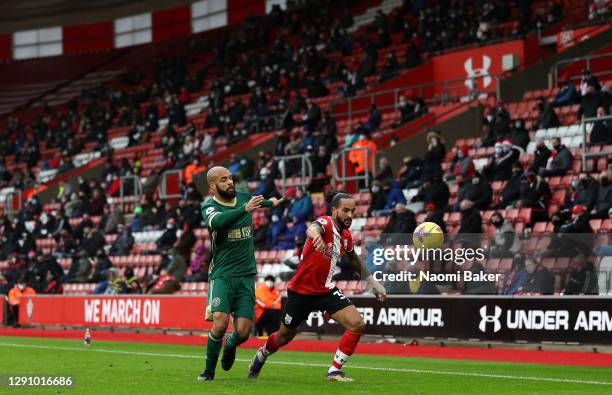 Theo Walcott of Southampton battles for possession with David McGoldrick of Sheffield United battle for the ball in front of the fans during the...