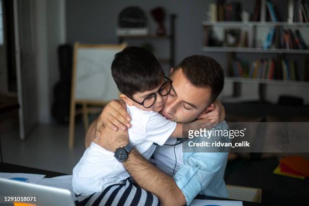 happy dad and preschooler son relax on couch together - parent stock pictures, royalty-free photos & images