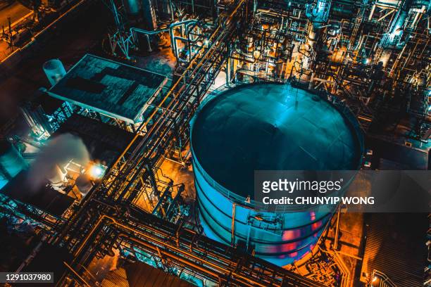 distillation tank of oil refinery plant at night - oil refinery stock pictures, royalty-free photos & images