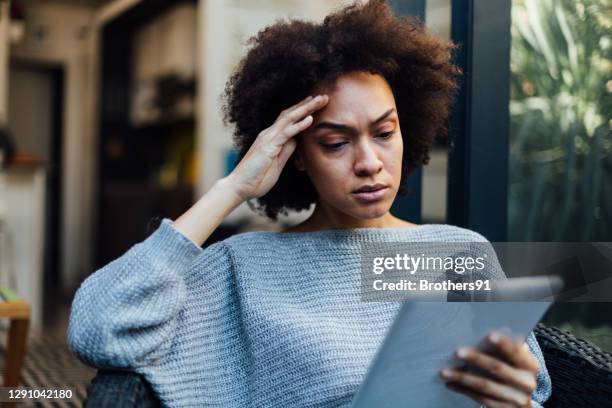 young african american woman reading bad news on her mobile device - surprised woman looking at tablet stock pictures, royalty-free photos & images