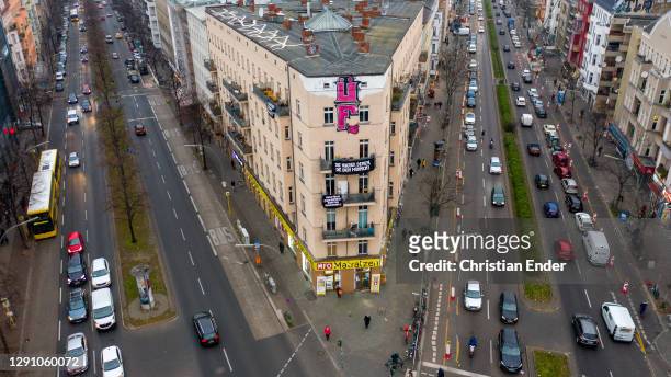 In this areal view a banner hangs at the facade of a balcony saying "The houses to those who live in them" at Hermannplatz in the district Neukoelln...
