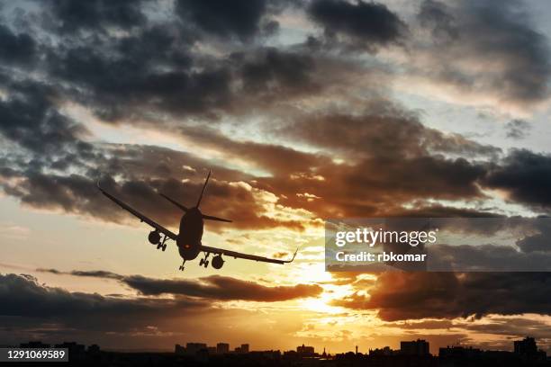 silhouette of a business plane flying over the city and making an emergency landing at night - aterragem de emergência imagens e fotografias de stock