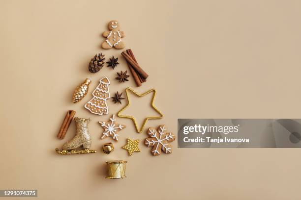 creative christmas tree made of golden decorations on beige background. christmas, winter, new year concept. flat lay, top view, copy space. - gold colored imagens e fotografias de stock