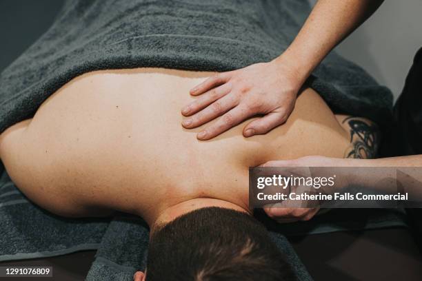 physio massages a patients neck - huile de massage photos et images de collection