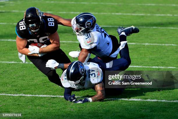 Tyler Eifert of the Jacksonville Jaguars is tackled by Kevin Byard of the Tennessee Titans at TIAA Bank Field on December 13, 2020 in Jacksonville,...