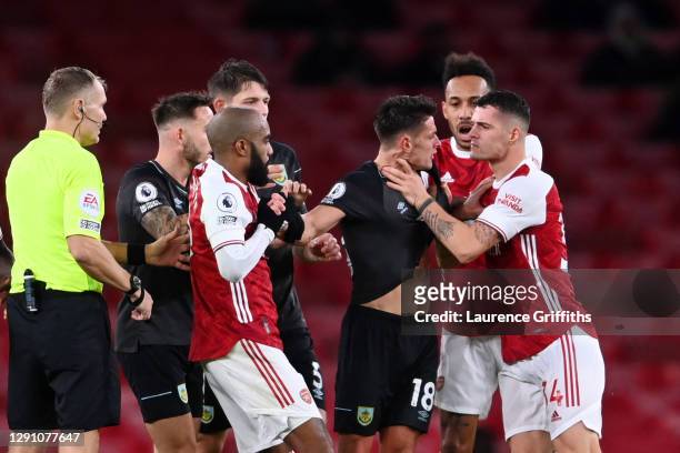 Granit Xhaka of Arsenal grabs Ashley Westwood of Burnley round the throat and is subsequently shown a red card and sent off after a VAR check during...