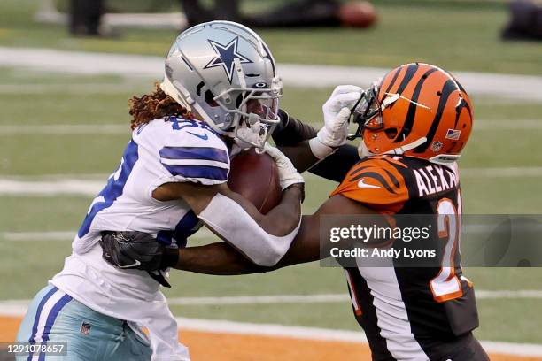 CeeDee Lamb of the Dallas Cowboys runs with the ball while being tackled by Mackensie Alexander of the Cincinnati Bengals in the fourth quarter at...