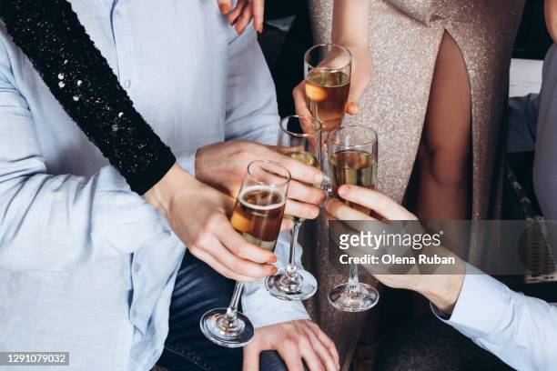 men and women hold glasses of champagne in their hands - christmas drinks stockfoto's en -beelden