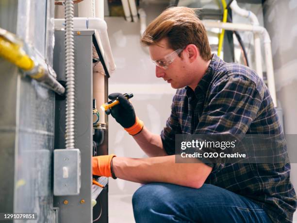 home repairman working on a furnace - furnace stock pictures, royalty-free photos & images