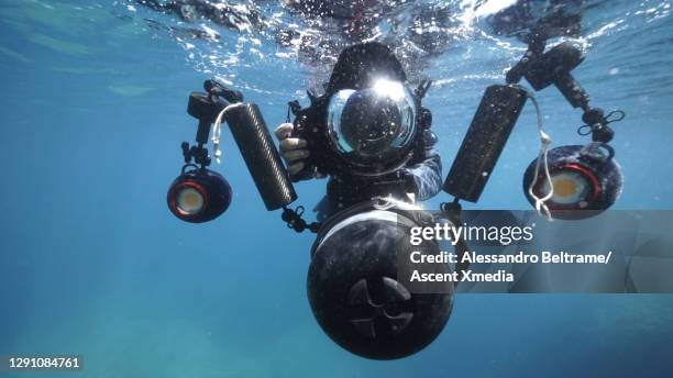 scuba diver descends into the sea with film and sound equipment - underwater film camera - fotografias e filmes do acervo