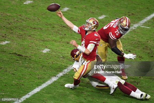Quarterback Nick Mullens of the San Francisco 49ers attempts a pass as he is tackled by defensive tackle Jonathan Allen of the Washington Football...