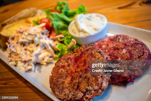 hamburguesas de quinoa y semillas, con papas asadas, ensalada fresca y aderezo de queso de pepino y menta (comida vegetariana). - ensalada de quinoa stock pictures, royalty-free photos & images