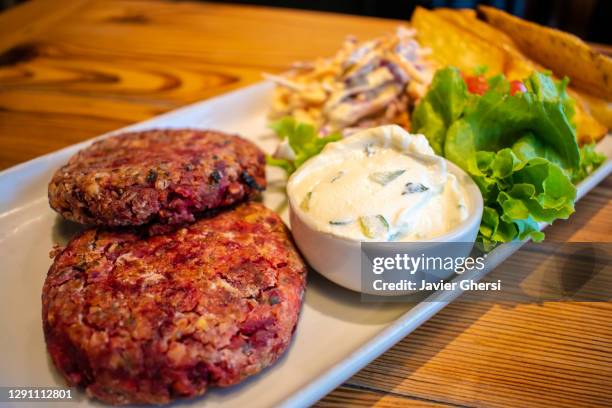 hamburguesas de quinoa y semillas, con papas asadas, ensalada fresca y aderezo de queso de pepino y menta (comida vegetariana). - ensalada de quinoa stock pictures, royalty-free photos & images