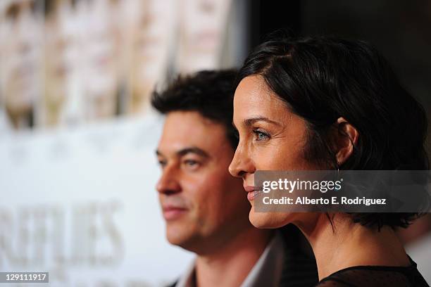 Actress Carrie-Anne Moss and Steven Roy arrive at the "Fireflies In The Garden" Premiere at Pacific Theaters at the Grove on October 12, 2011 in Los...