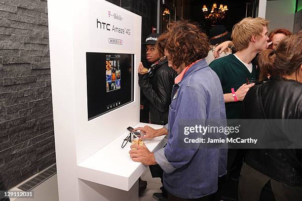 Guests attend T-Mobil kiosk at the launch of T-Mobile's new Android-Powered Samsung Galaxy S II and HTC Amaze 4G at Espace on October 12, 2011 in New...