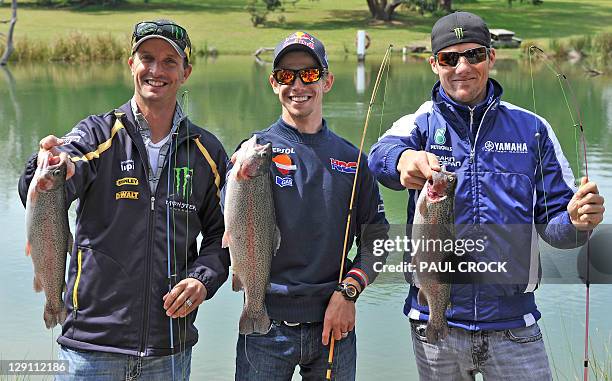 Yamaha rider Ben Spies of the US , Honda rider Casey Stoner of Australia and Yamaha rider Colin Edwards of the US hold up fish they at a trout farm...