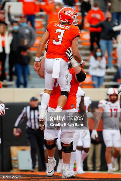 Guard Josh Sills lifts up quarterback Spencer Sanders of the Oklahoma State Cowboys as they celebrate his nine-yard touchdown run against the Texas...