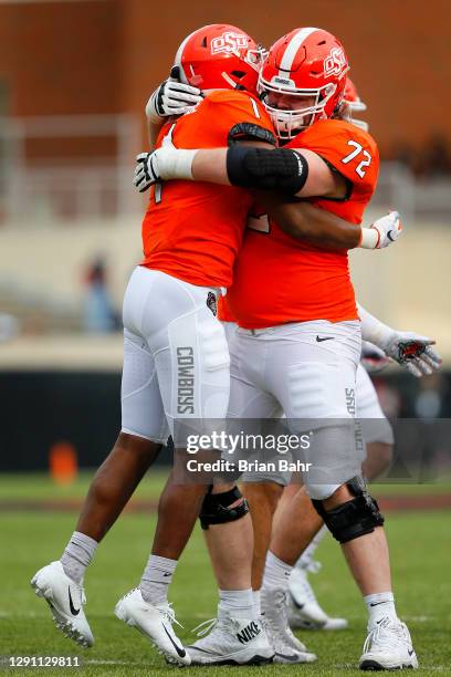 Linebacker Calvin Bundage of the Oklahoma State Cowboys celebrates a sack for a safety against the Texas Tech Red Raiders with guard Josh Sills in...