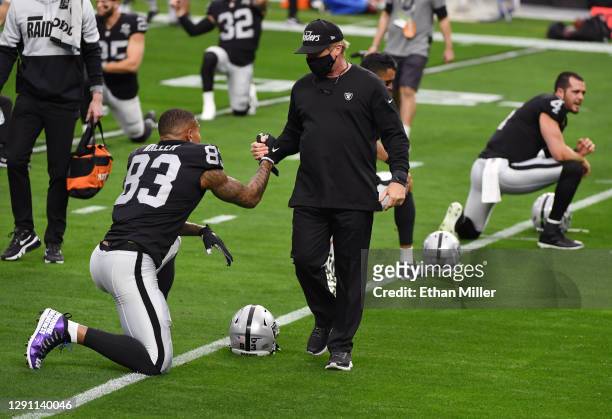 Head coach Jon Gruden of the Las Vegas Raiders greets tight end Darren Waller as he stretches during warmups before their game against the...
