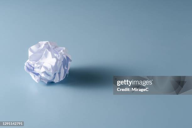 a crumpled paper ball on blue - paper ball stock pictures, royalty-free photos & images