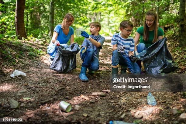 family cleaning trash in the forest - picking up imagens e fotografias de stock