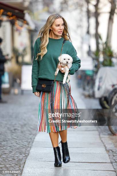 German actress Xenia Seeberg wearing a multicolored midi length pleated skirt by Fate Kastrati, a sage green colored sweatshirt by Fate Kastrati, a...