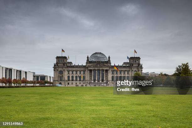 reichstag building with dark clouds (deutscher bundestag, berlin/ germany) - central berlin stock-fotos und bilder