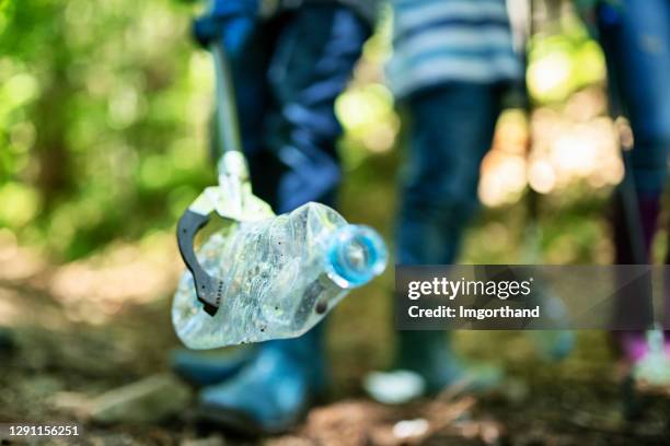 familie die afval in het bos schoonmaakt - pliers stockfoto's en -beelden