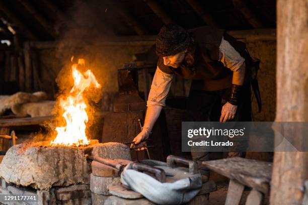 ein individueller wikingerschmied in einer wikingersiedlung - historical reenactment stock-fotos und bilder