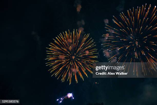 exploding fireworks against night sky - firework explosive material stock pictures, royalty-free photos & images