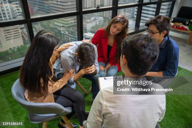 group of young people sitting in a circle and talking to psychiatrist during a therapy - suicide stock pictures, royalty-free photos & images