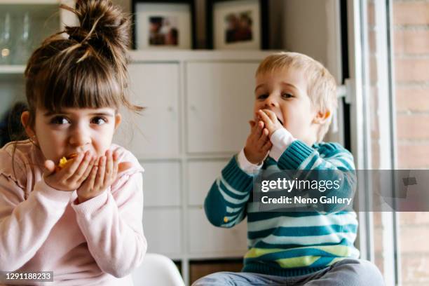 brother and sister eating cereal - hands full stock pictures, royalty-free photos & images