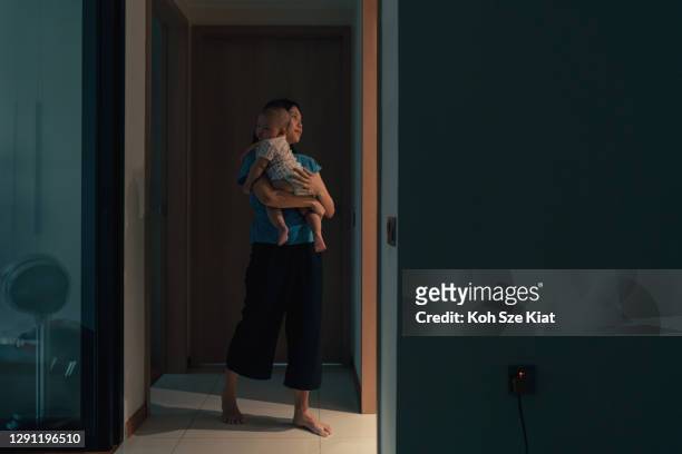 asian mother attending to the newborn's needs in the middle of the night - waking up stock pictures, royalty-free photos & images