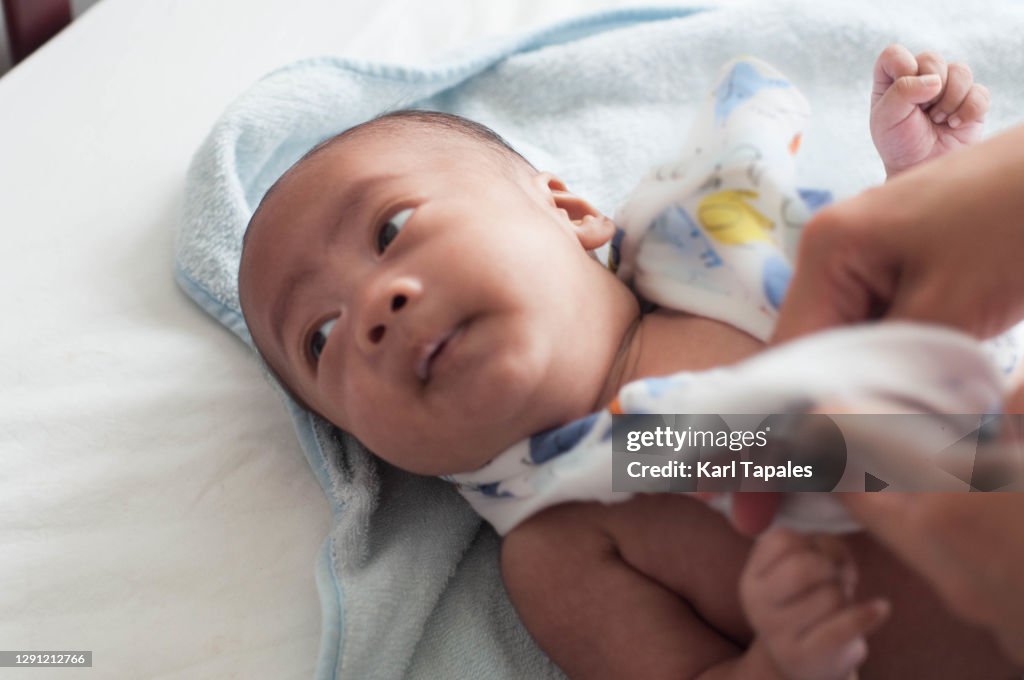 Southeast Asian baby boy changing clothes