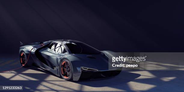 electric sports car charging in dark garage lit from skylight - audi stock pictures, royalty-free photos & images