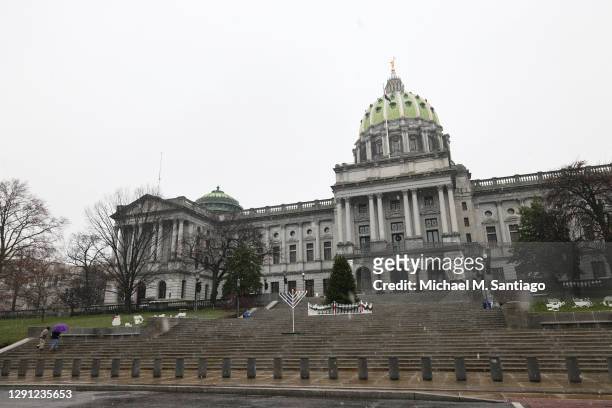 People walk up the steps of the Pennsylvania State Capitol on December 14, 2020 in Harrisburg, Pennsylvania. Electors in Pennsylvania will meet today...