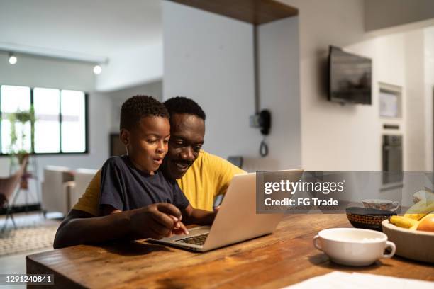 grandfather helping grandson studying or working at home - afro friends home stock pictures, royalty-free photos & images