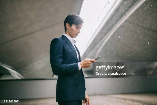 hombre que se refugia de la lluvia - singapore man portrait fotografías e imágenes de stock