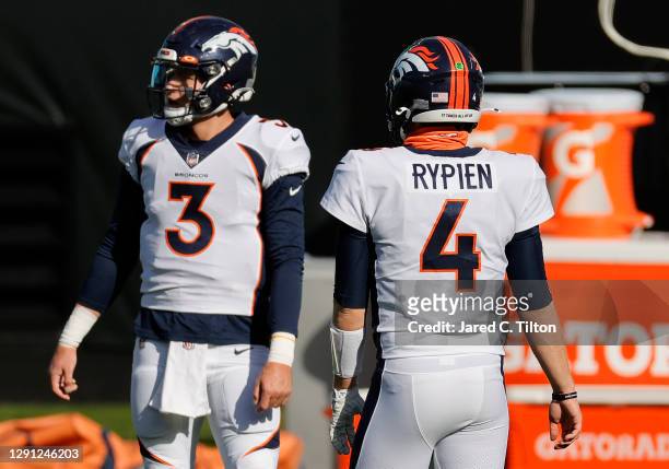Quarterbacks Drew Lock and Brett Rypien the Denver Broncos look on prior to their game against the Carolina Panthers at Bank of America Stadium on...